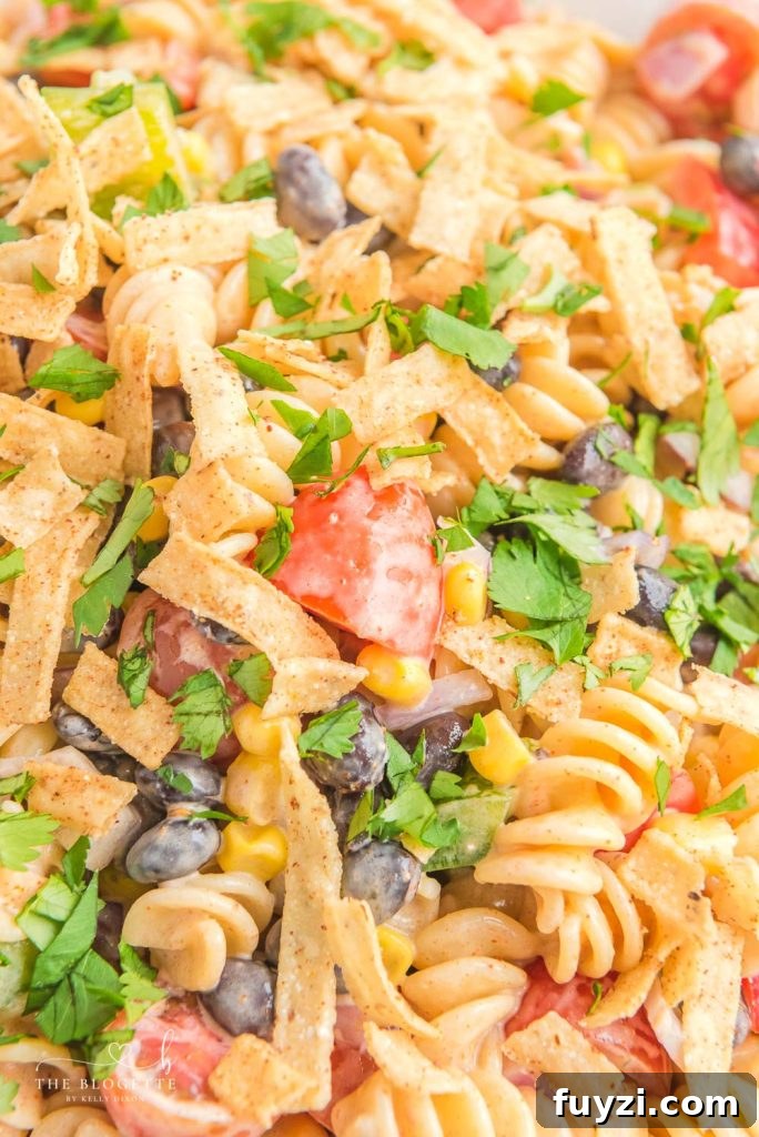 Creamy Ranch Taco Pasta Salad - Ranch dressing and taco seasoning folded into pasta with tomatoes, beans, corn, and more!