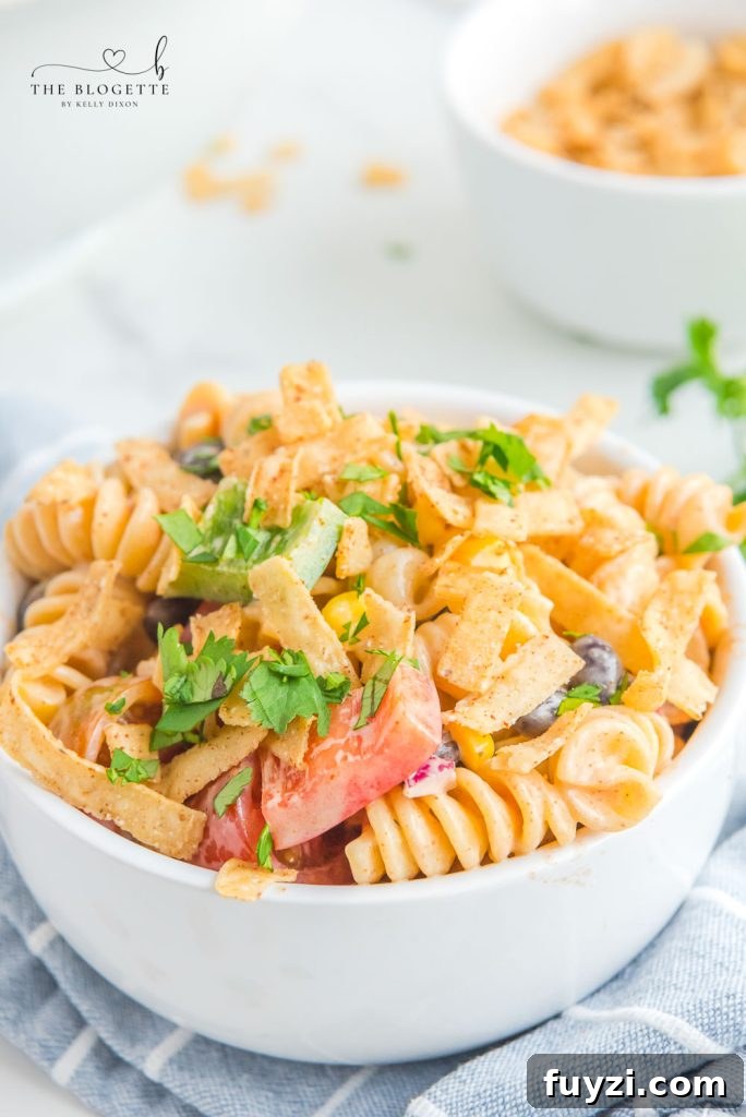 Creamy Ranch Taco Pasta Salad - Ranch dressing and taco seasoning folded into pasta with tomatoes, beans, corn, and more!