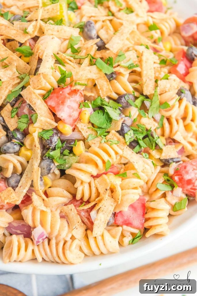 Creamy Ranch Taco Pasta Salad - Ranch dressing and taco seasoning folded into pasta with tomatoes, beans, corn, and more!