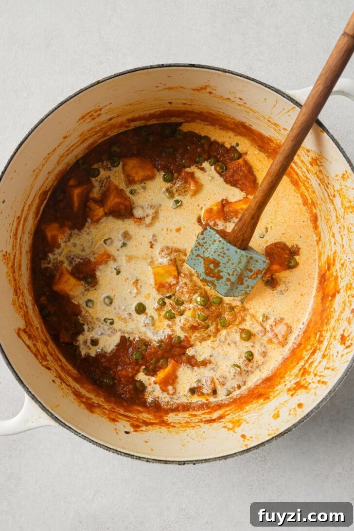 Authentic Restaurant-Style Matar Paneer Recipe 15 Adding cream to Matar Paneer.