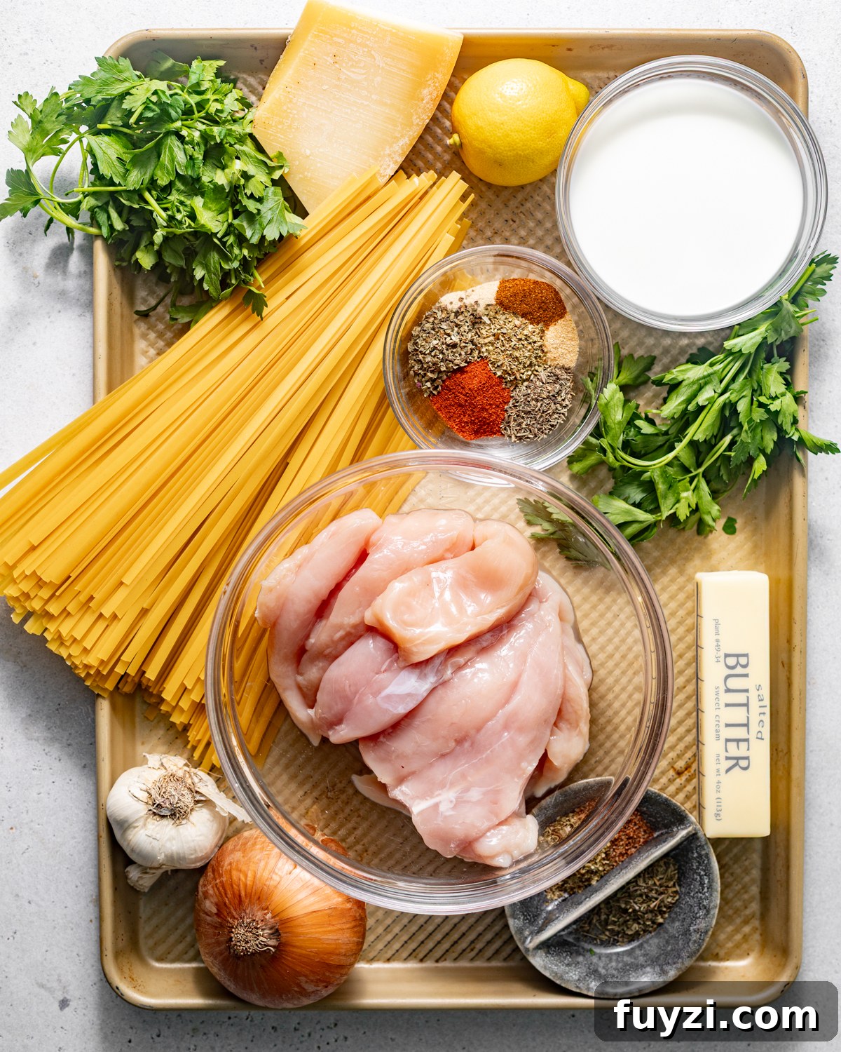 ingredients to make blackened chicken alfredo on a baking sheet.