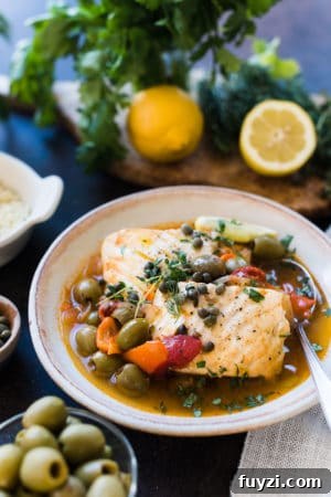 Instant Pot Fish Stew: Tomatoes, Olives and Capers 10 Instant Pot Fish Stew with Tomatoes, Olives and Capers in a cream bowl.