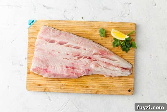 raw filleted catfish on chopping board