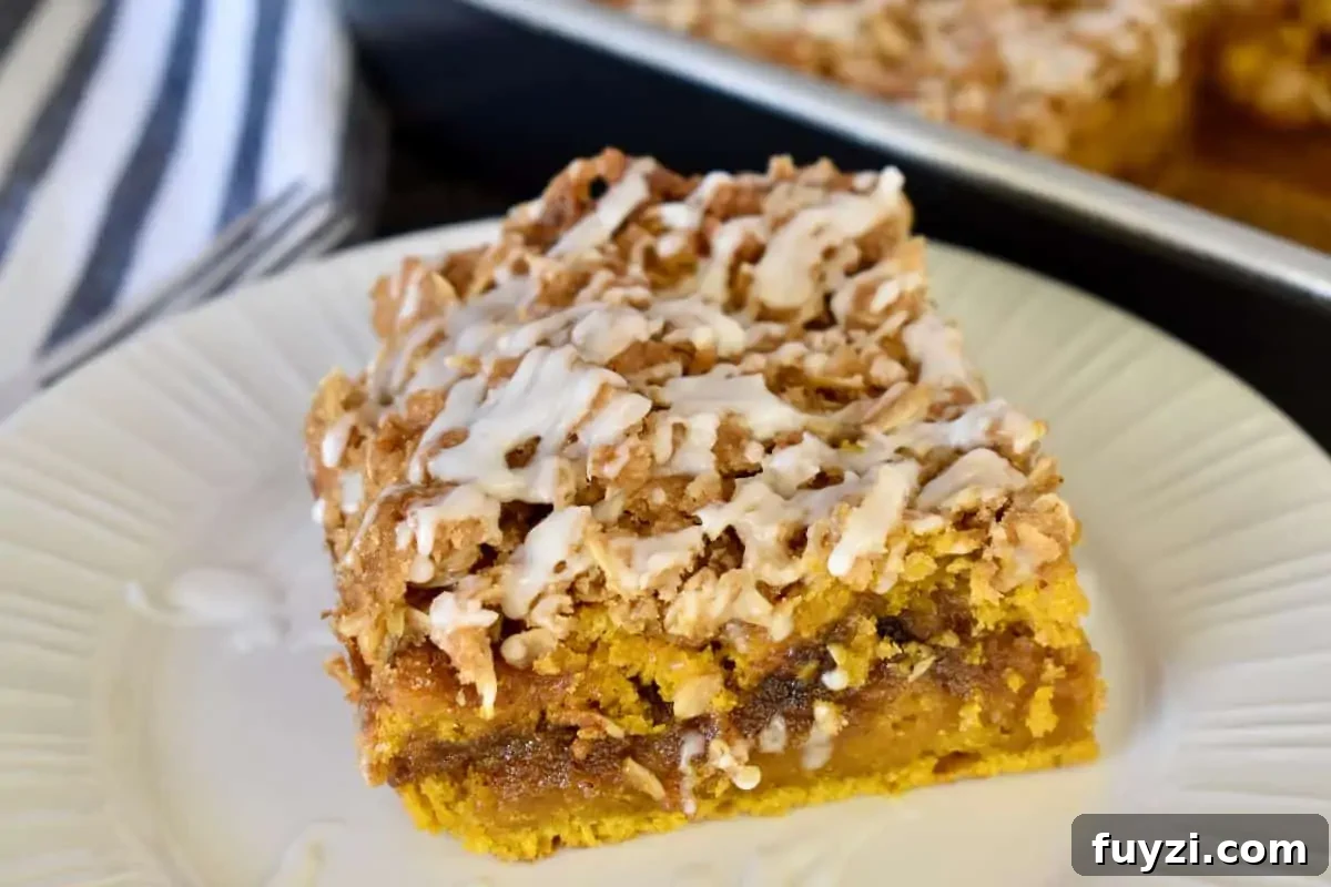 Pumpkin Streusel Coffee Cake Recipe with Cinnamon Crumble 3 Slice of pumpkin streusel coffee cake on a stack of white plates.