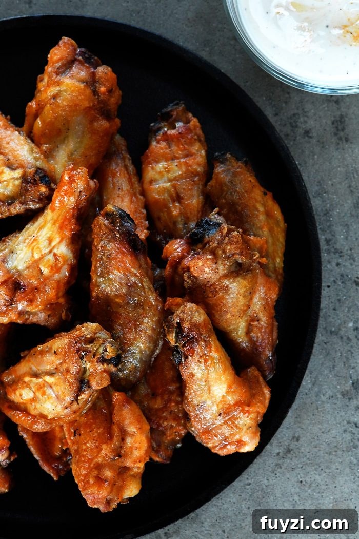 Baked Crispy Buffalo Chicken Wings Recipe - Crispy buffalo wings no longer have to be deep fried to be delicious! This easy recipe for baked chicken wings makes everyone's favorite wing even better! // addapinch.com