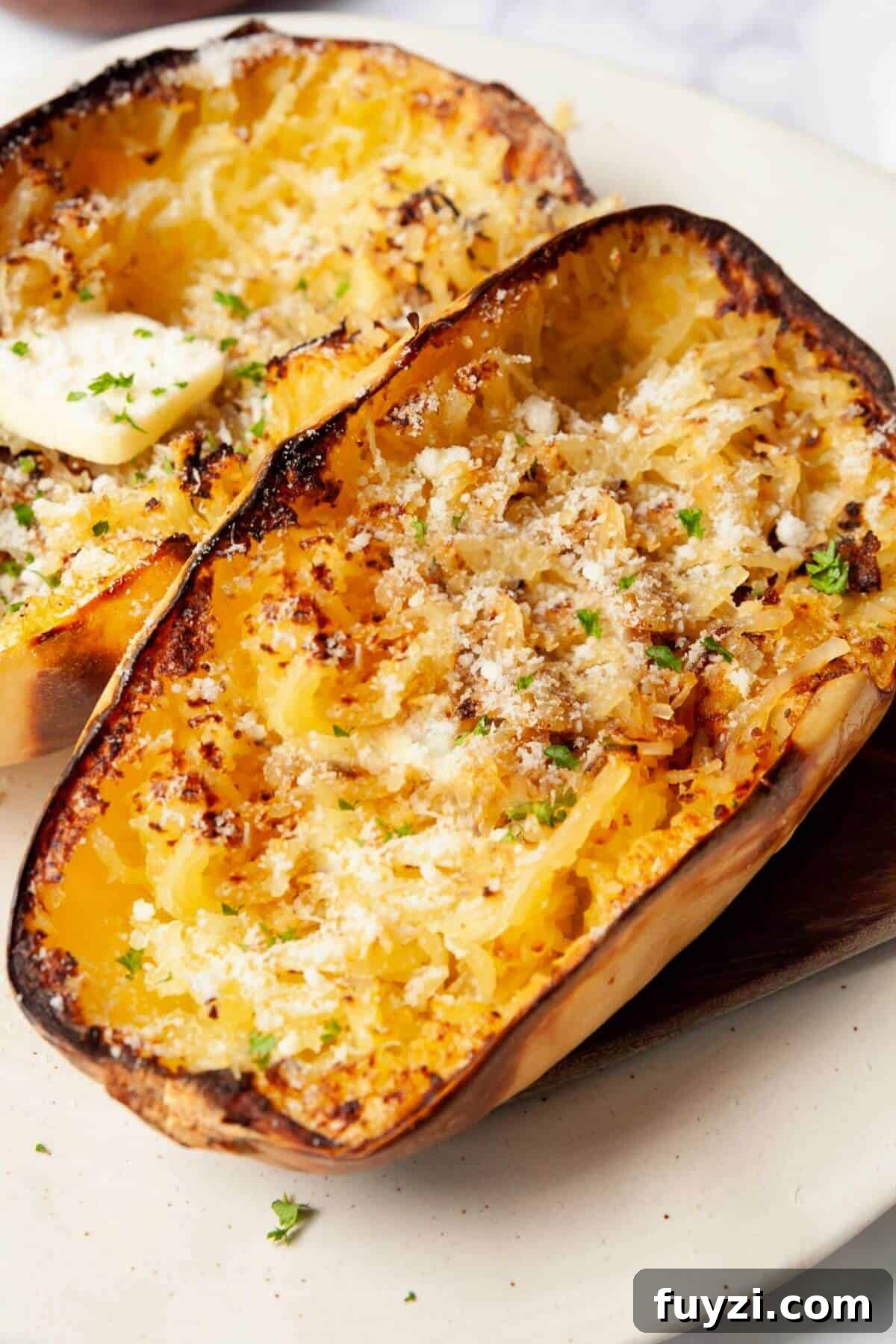Fluffy air fryer spaghetti squash noodles topped with melted butter and grated parmesan.