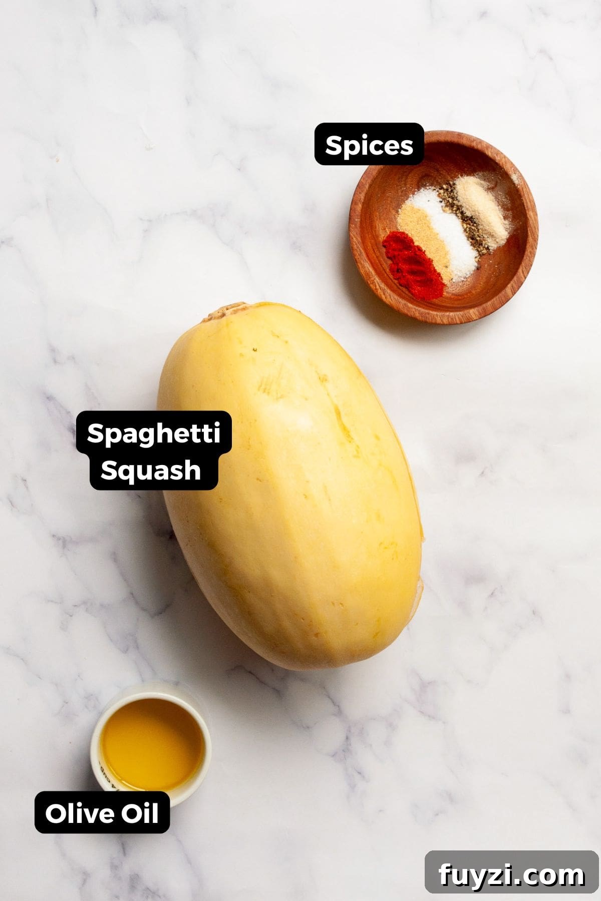 All labeled ingredients for air fryer spaghetti squash, including spaghetti squash, olive oil, salt, black pepper, garlic powder, onion powder, and paprika.