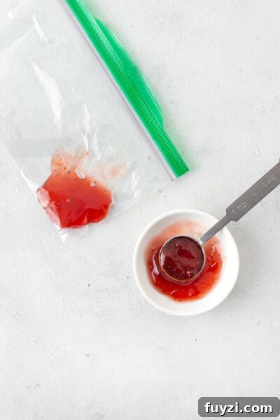 Mini Jam Sandwiches for Afternoon Tea 6 Strawberry jam being placed into zip-top bag.