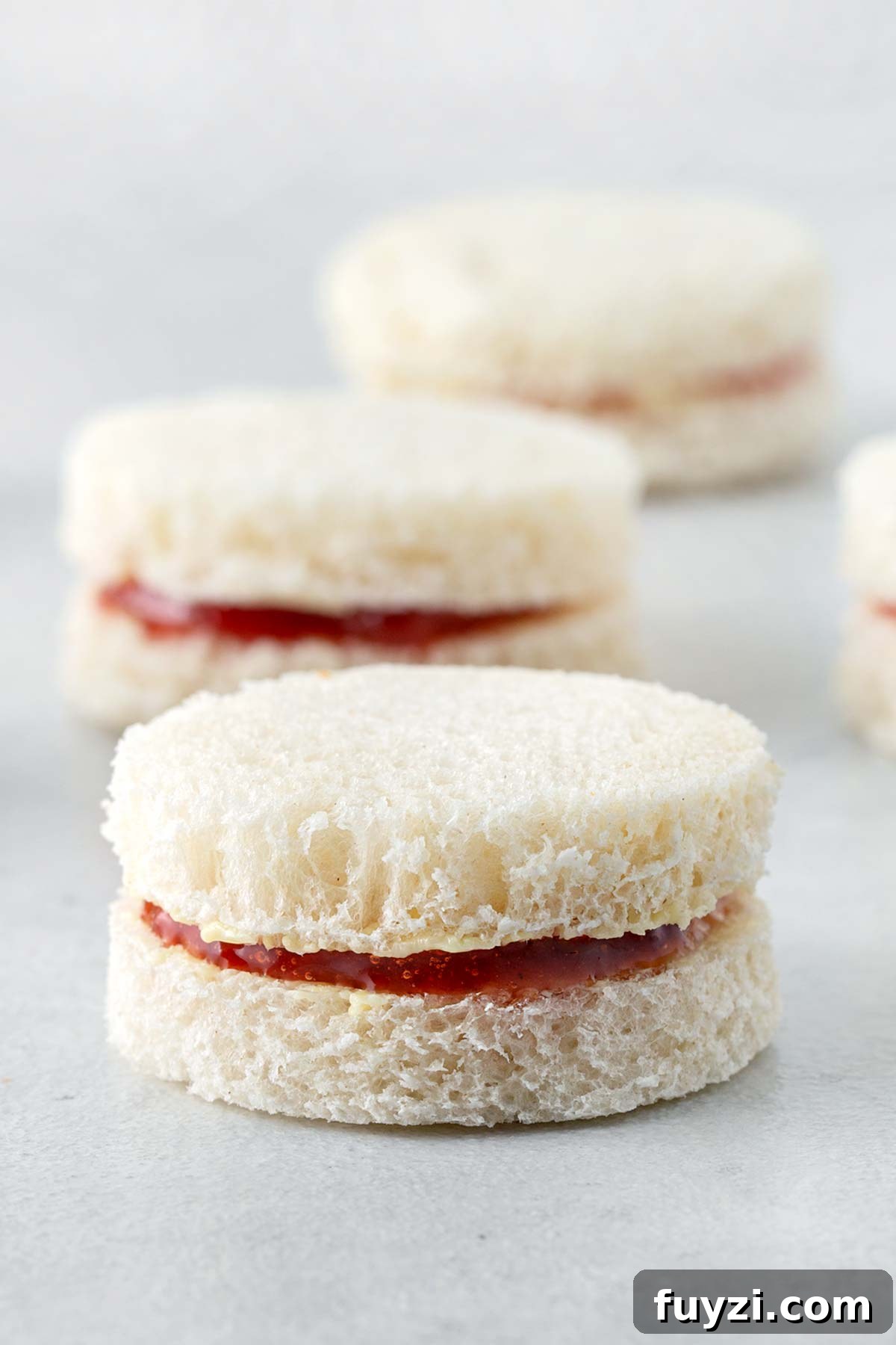 Mini Jam Sandwiches for Afternoon Tea 9 Close up of one Jam Pennies Tea Sandwich with others in the background.