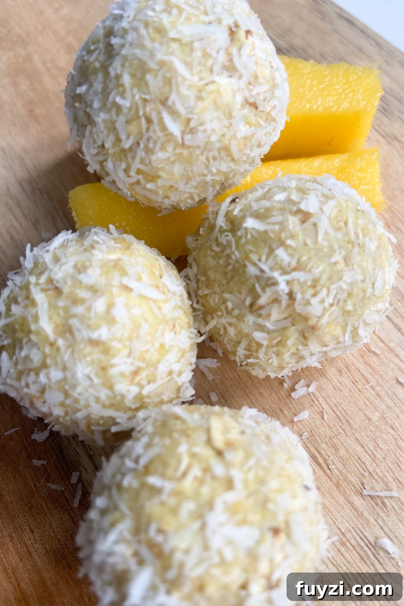 Mango bliss balls served with sliced mangoes