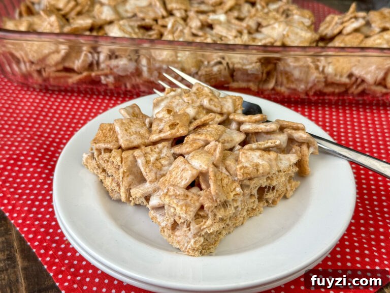Copycat Cinnamon Toast Crunch Cereal Bars Recipe 2 Close up squares of cinnamon toast crunch coated with melted marshmallows and stuck together in a delicious treat on a white plate.