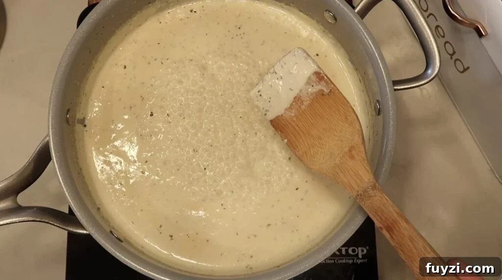 Silky Garlic Cream Sauce Recipe for Pasta and Chicken 14 Sauce thickened in pan and coating the back of a spoon
