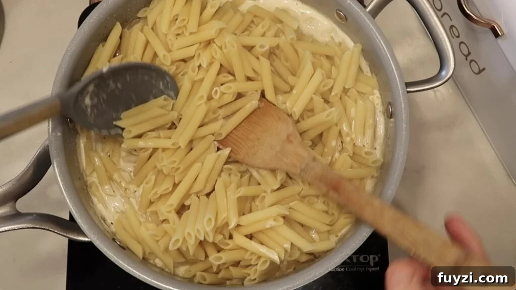 Silky Garlic Cream Sauce Recipe for Pasta and Chicken 16 Tossing pasta with sauce