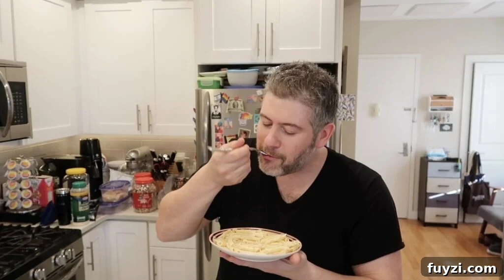 Silky Garlic Cream Sauce Recipe for Pasta and Chicken 19 Man trying sauce with pasta.