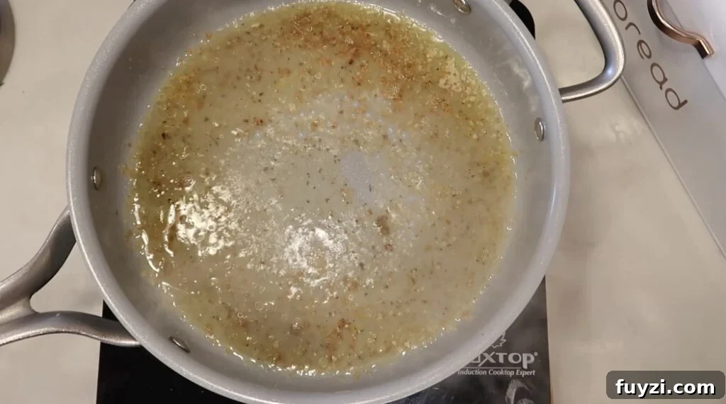 Silky Garlic Cream Sauce Recipe for Pasta and Chicken 8 Broth bubbling in pan