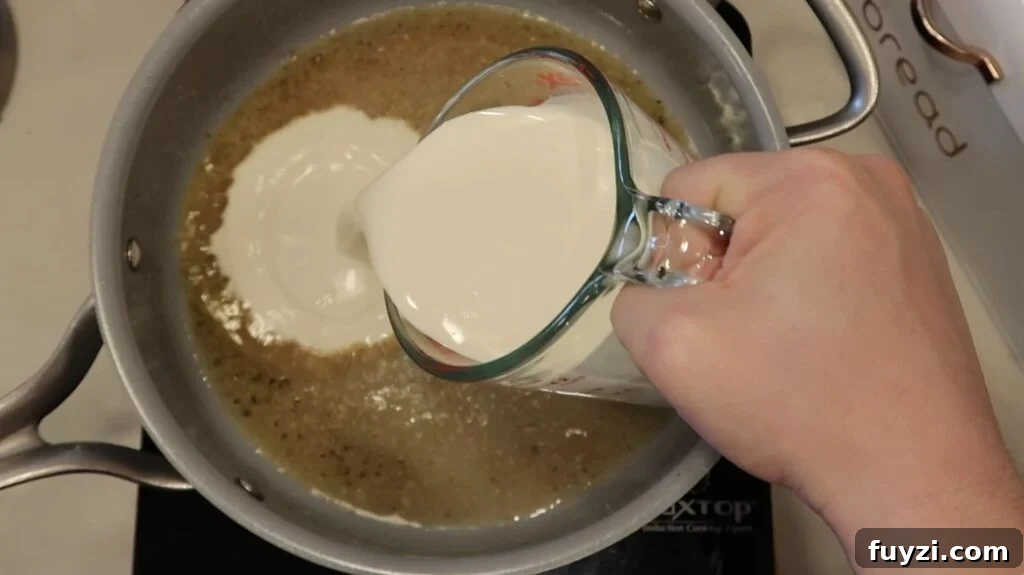 Silky Garlic Cream Sauce Recipe for Pasta and Chicken 9 Adding heavy cream to pan
