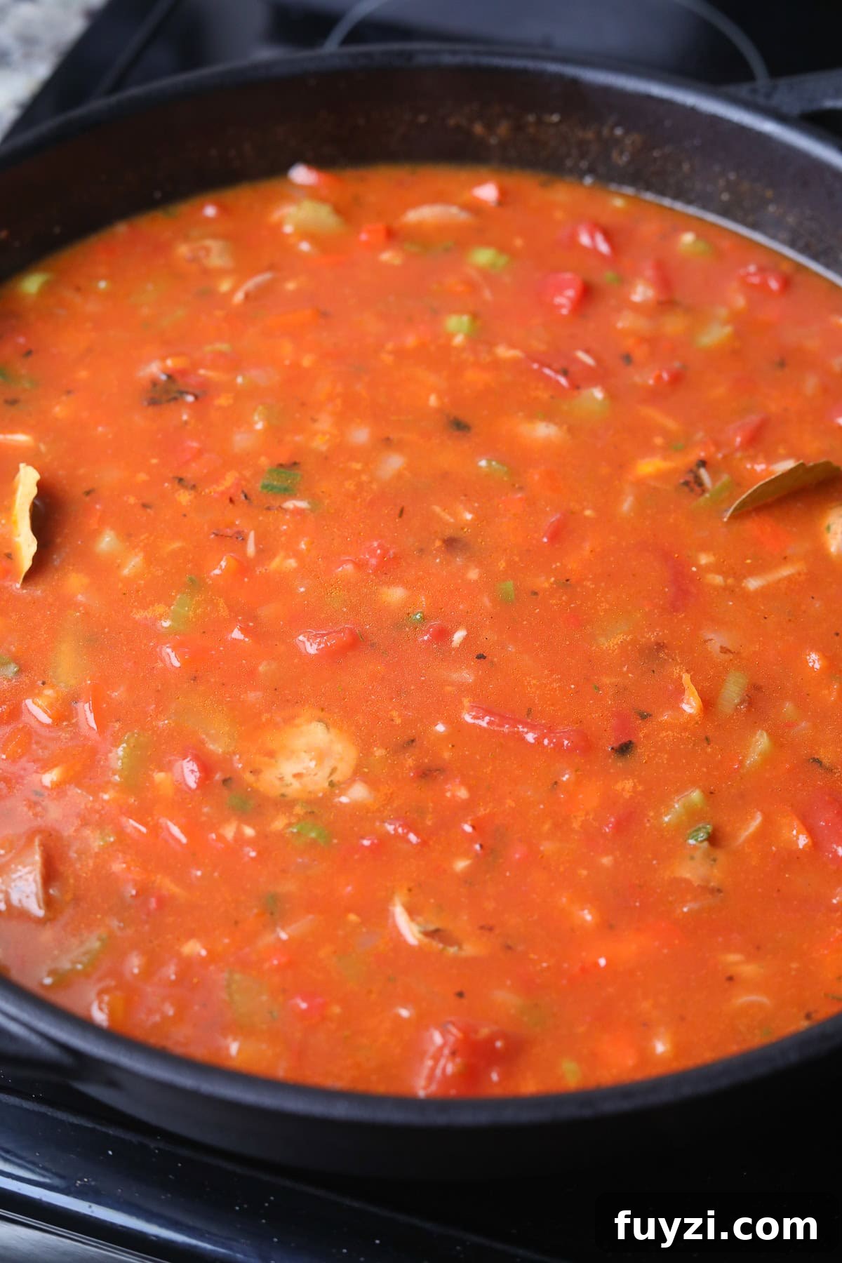 Shrimp and sausage jambalaya with rice simmering on the stove top