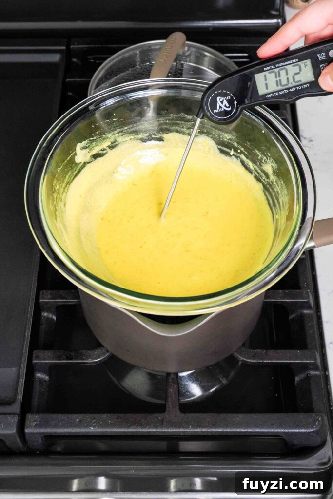 An instant-read thermometer in mango curd over the stove reads 170°F.