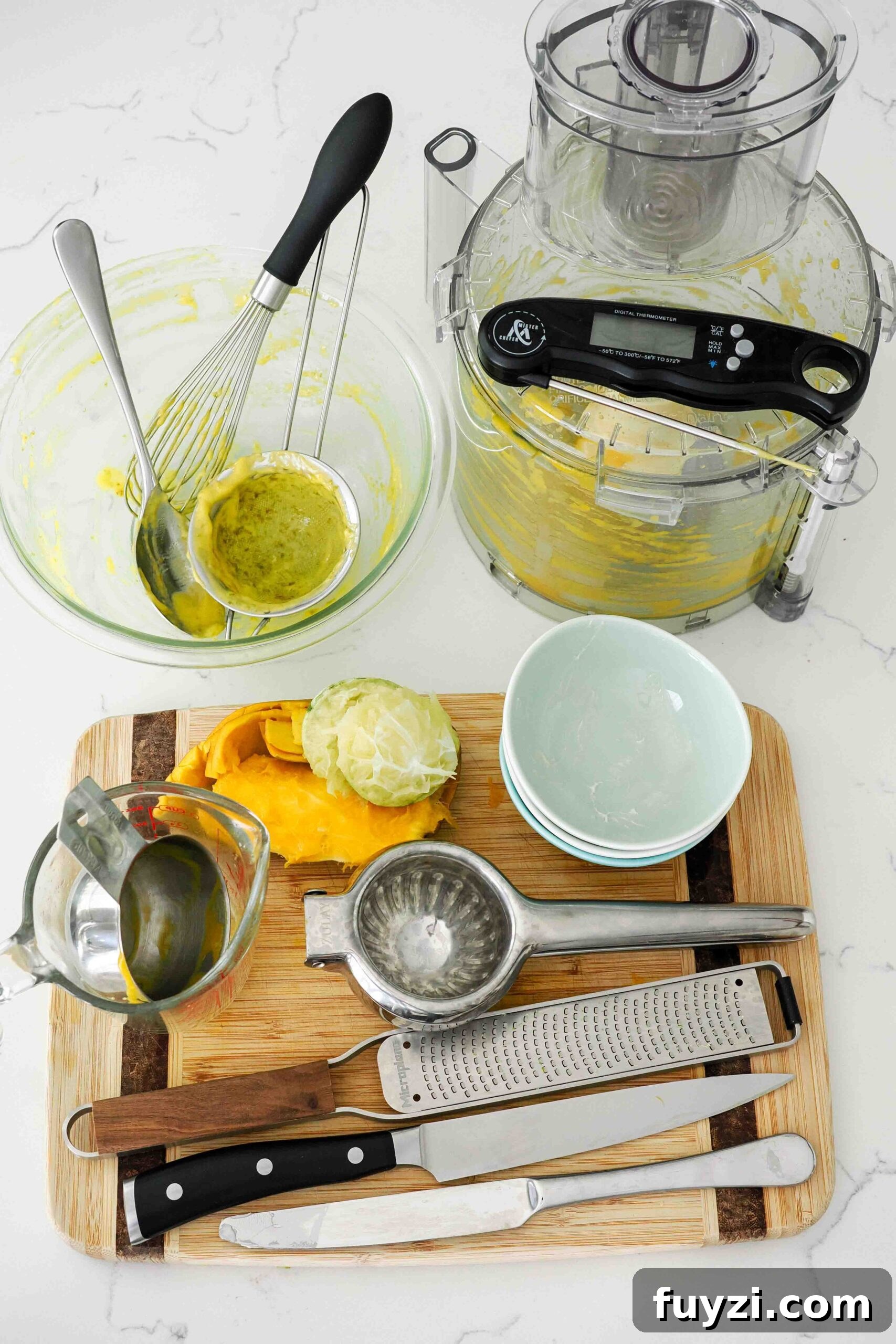 Dishes used to make small batch mango curd on a quartz countertop.