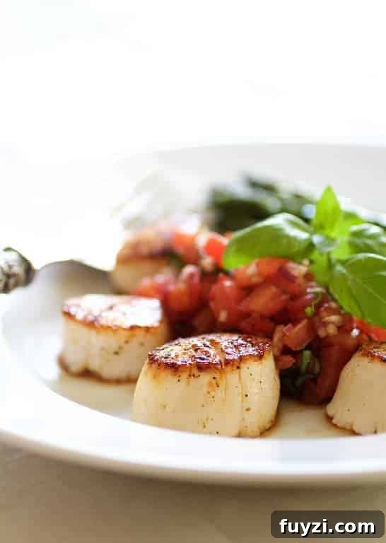 Close-up photo of Seared Sea Scallops with Tomato, Red Onion and Balsamic Salsa on white plate.