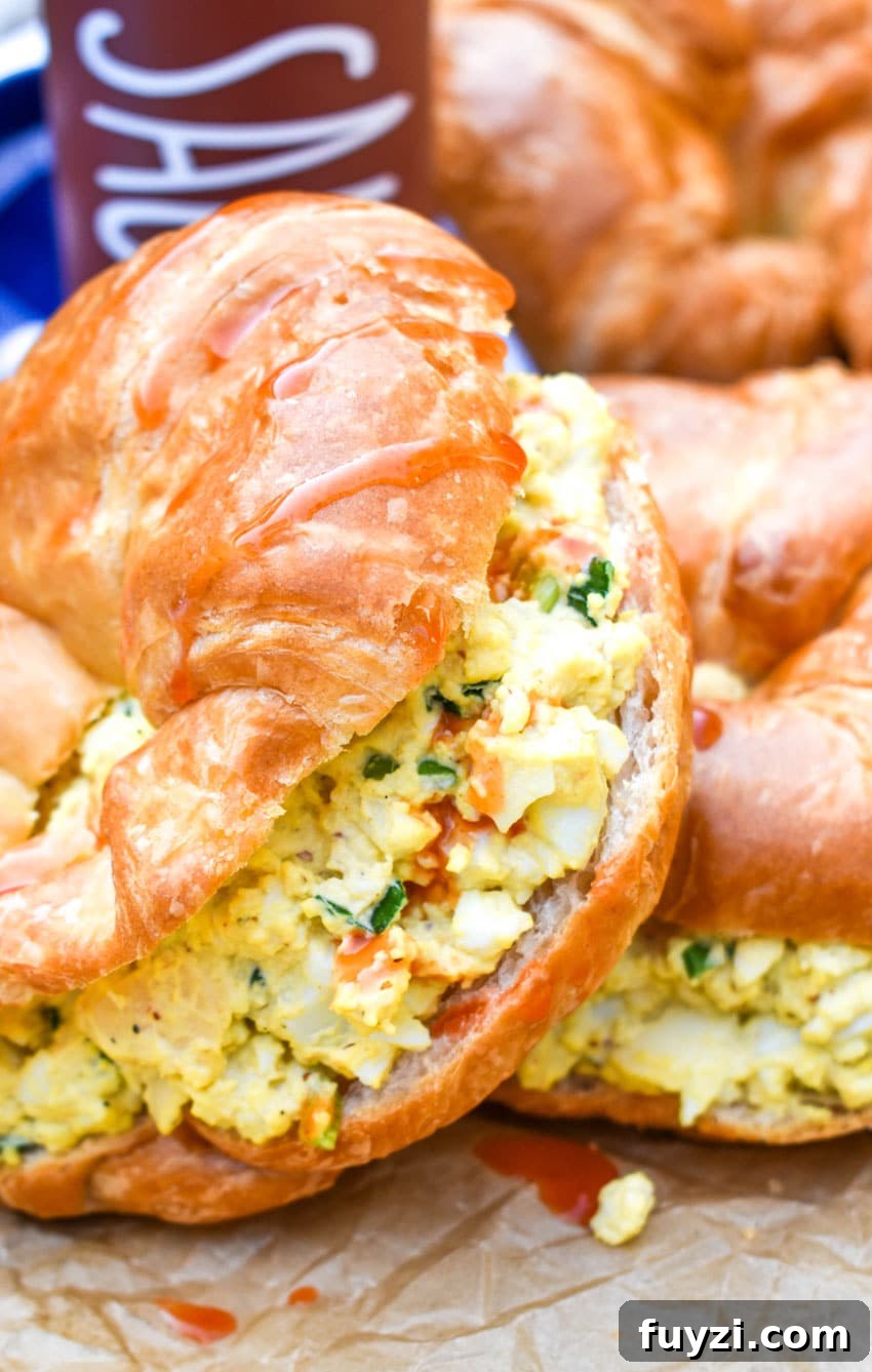 Smoked Egg Salad Recipe for Sandwiches and Salads 8 a croissant sandwich filled with smoked egg salad drizzled with hot sauce