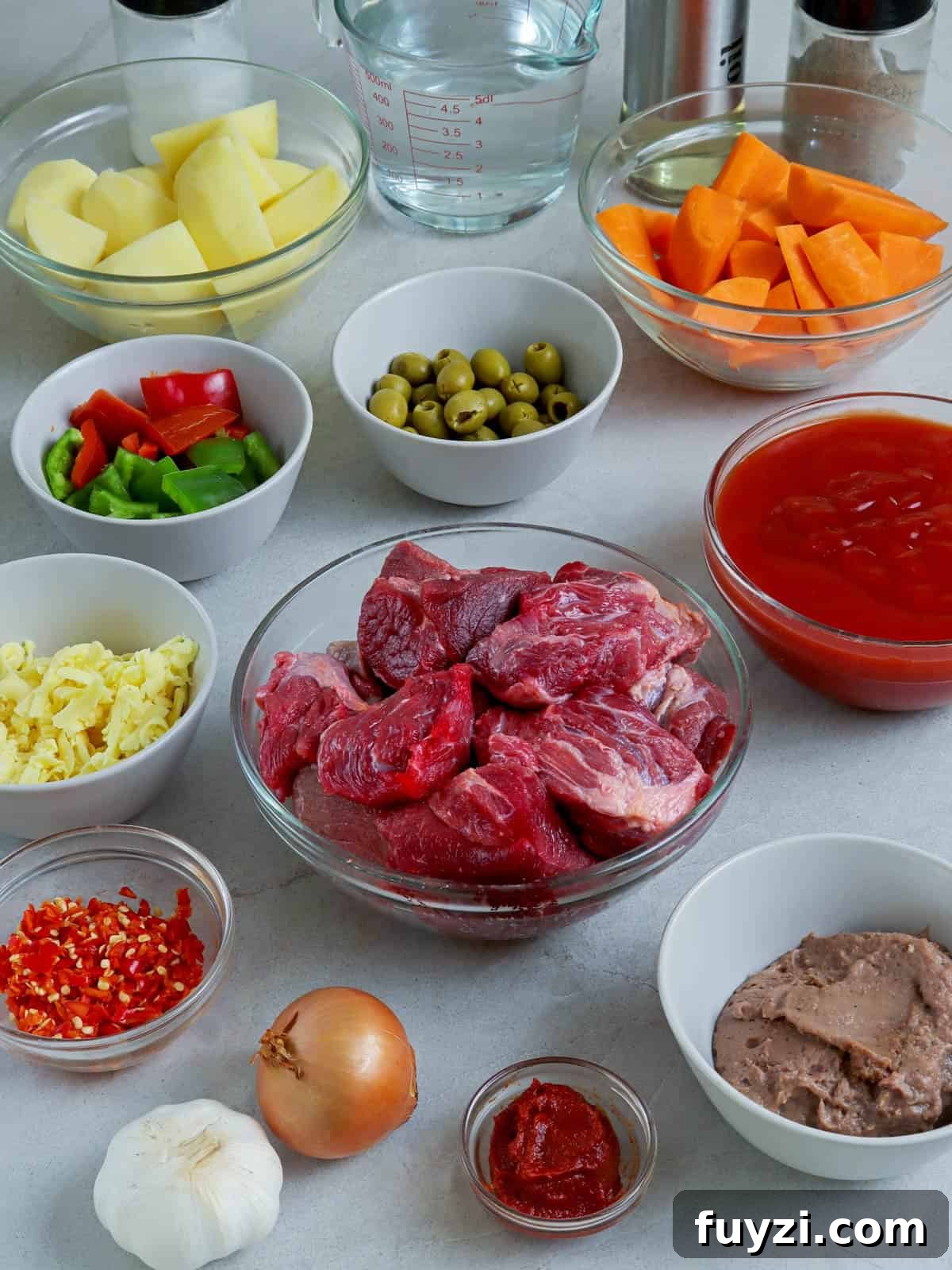 beef cubes, bell peppers, potatoes, carrots, liver spread, shredded cheese, tomato sauce, onions, garlic, olives