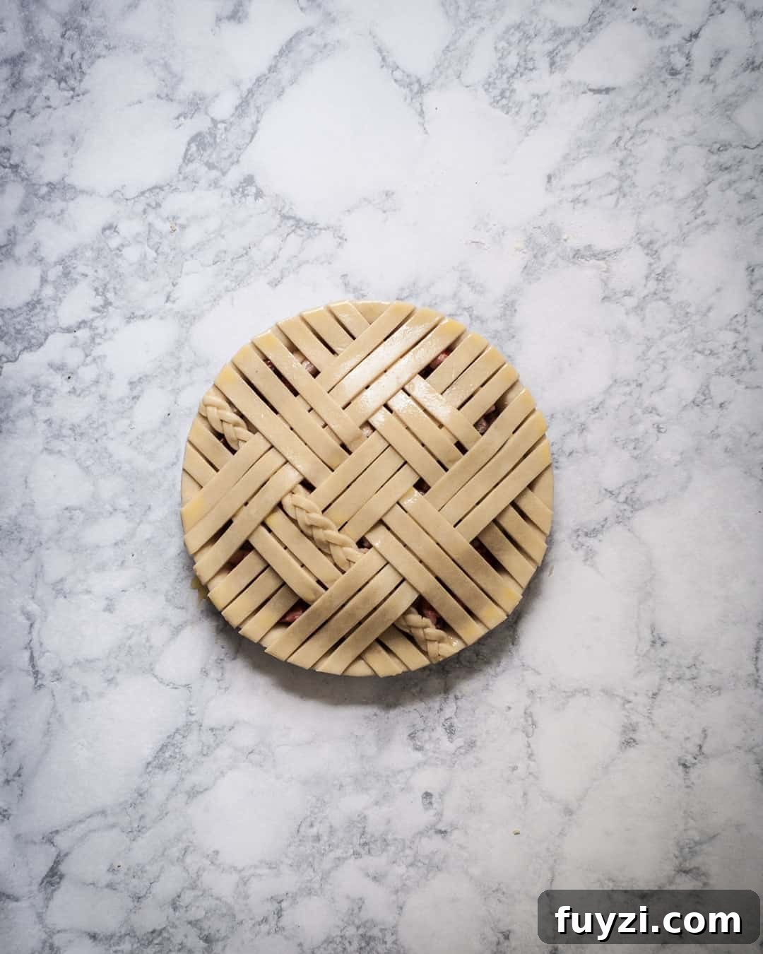 Process photo of a lattice pie with an egg wash.
