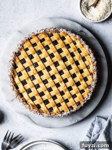 A baked pasta frola (quince tart) with thin lattice on top and a border of dessicated coconut.