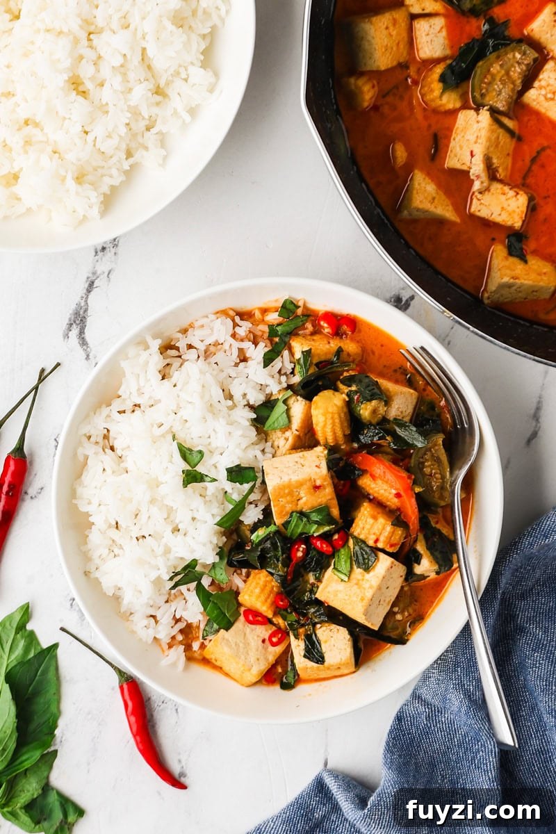 An overhead image of Thai red curry served on a plate with rice.
