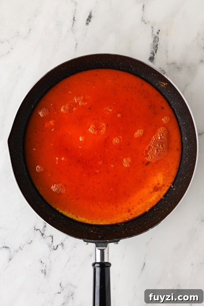 An overhead image of adding the thin part of coconut milk to the saucepan.