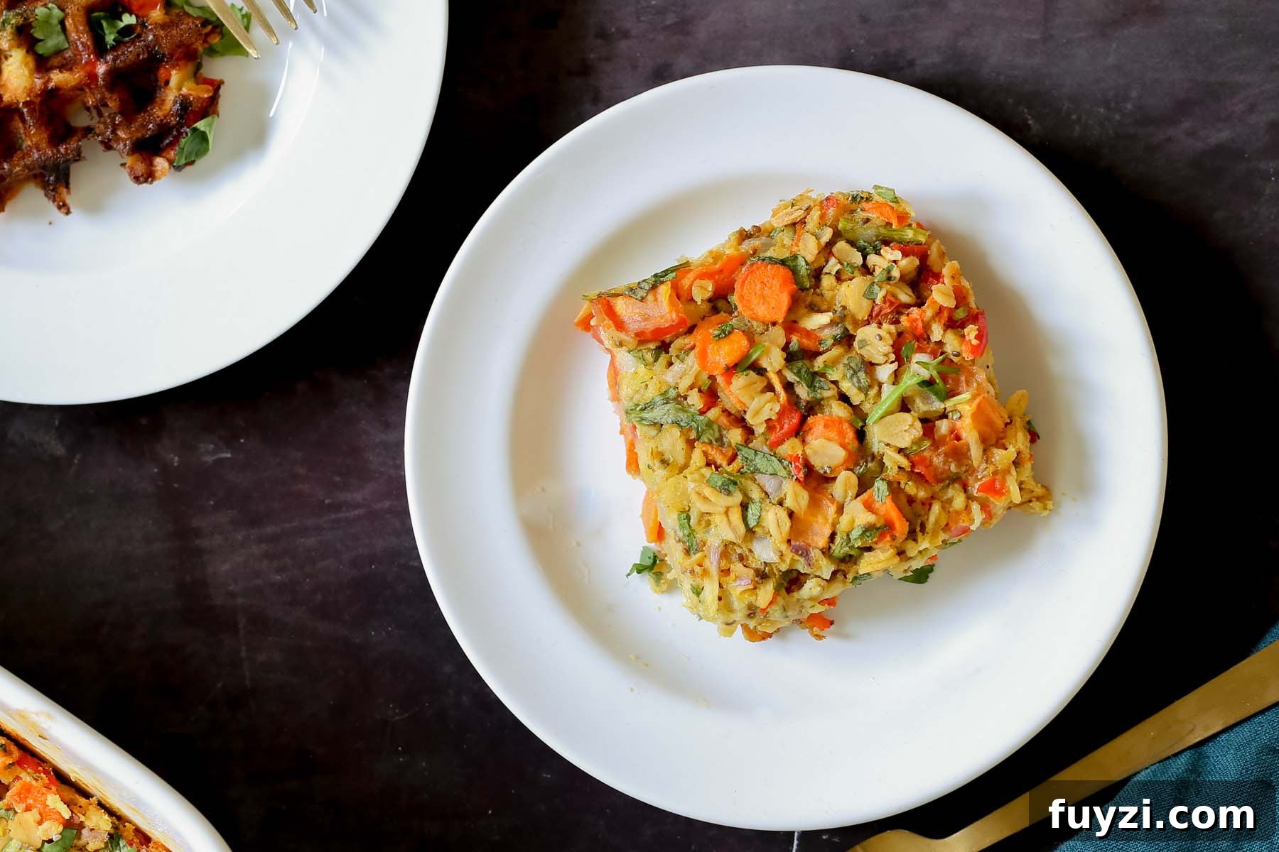 Savory Vegan Baked Oats with Roasted Vegetables 12 a piece of savory baked oatmeal on a white plate next to other breakfast items