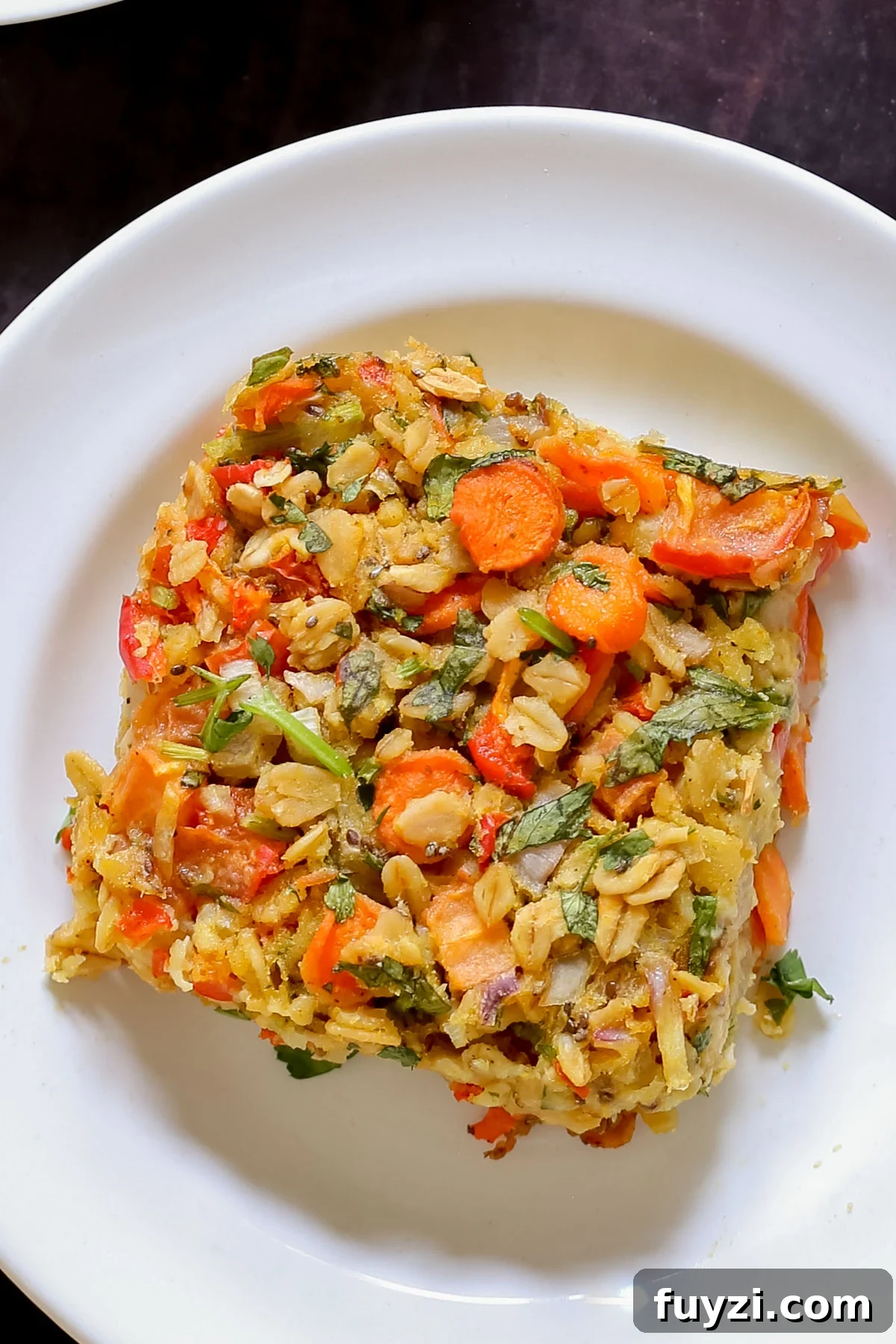 Savory Vegan Baked Oats with Roasted Vegetables 4 close-up of a piece of savory baked oatmeal on a white plate
