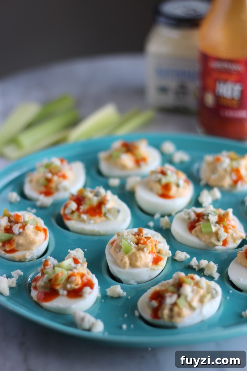 Buffalo Deviled Eggs - creamy deviled egg filling is combined with celery, blue cheese, and hot sauce for a spin on a classic. YUM. | fedandfulfilled.com