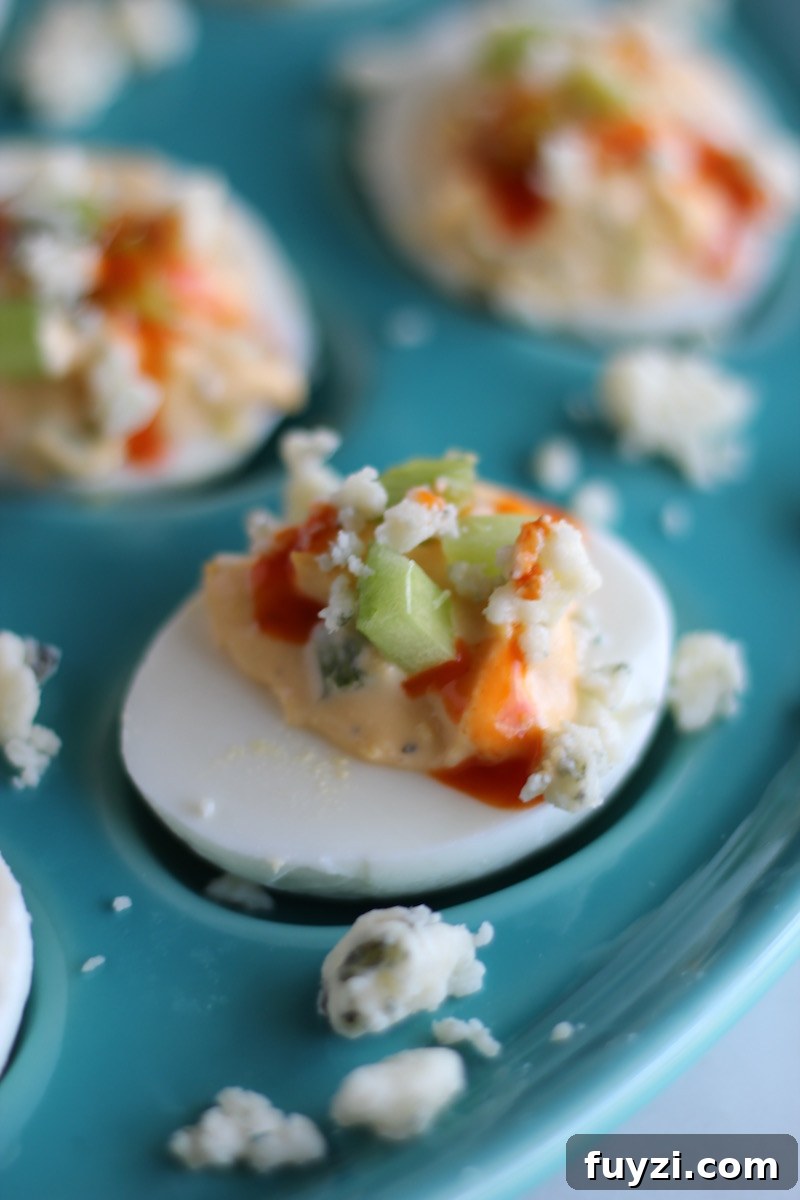 Buffalo Deviled Eggs - a five-ingredient, super easy deviled egg recipe that packs a punch with hot sauce and blue cheese! Party in your mouth! | fedandfulfilled.com