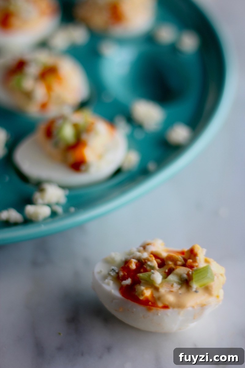 Buffalo Deviled Eggs - creamy deviled egg filling is loaded with blue cheese, hot sauce, and celery to create a colorful, flavorful take on a classic! | fedandfulfilled.com
