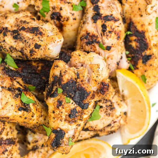 Grilled chicken with charred seasoning and fresh green herbs.