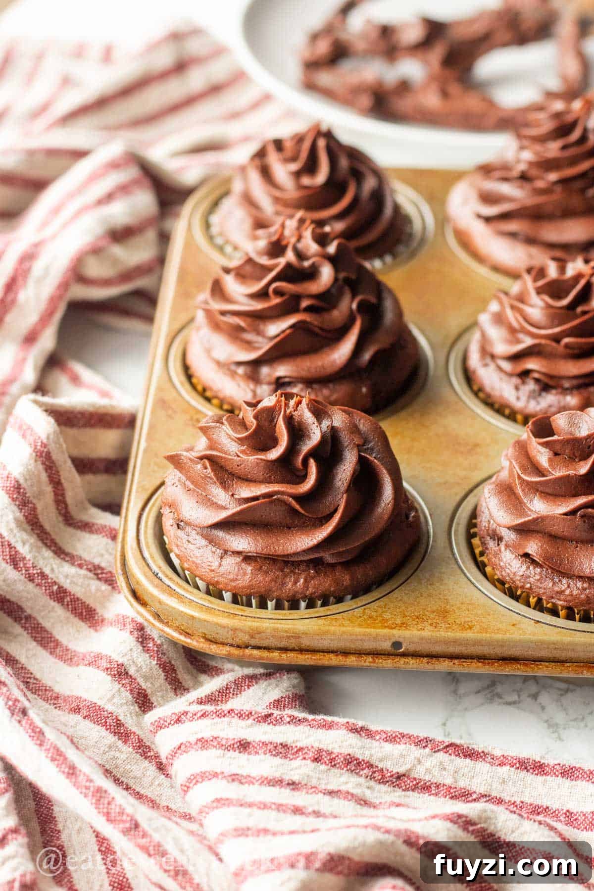 Gooey Chocolate Caramel-Filled Cupcakes Recipe 8 Chocolate frosted cupcakes in metal pan.