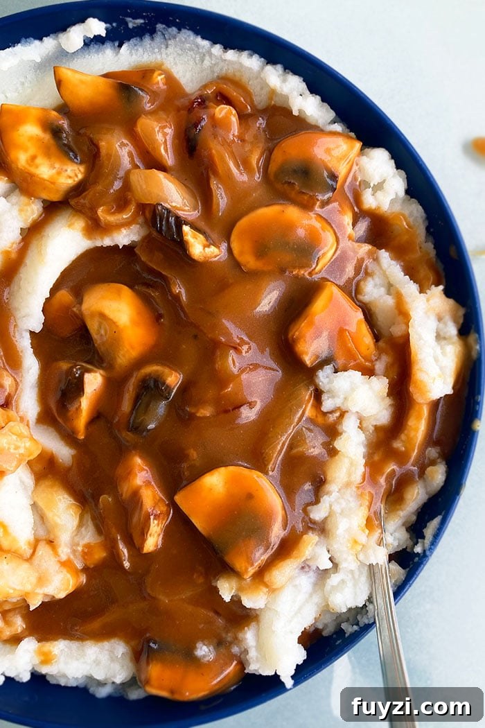 Homemade Mushroom Gravy Over Mashed Potatoes in Blue Bowl