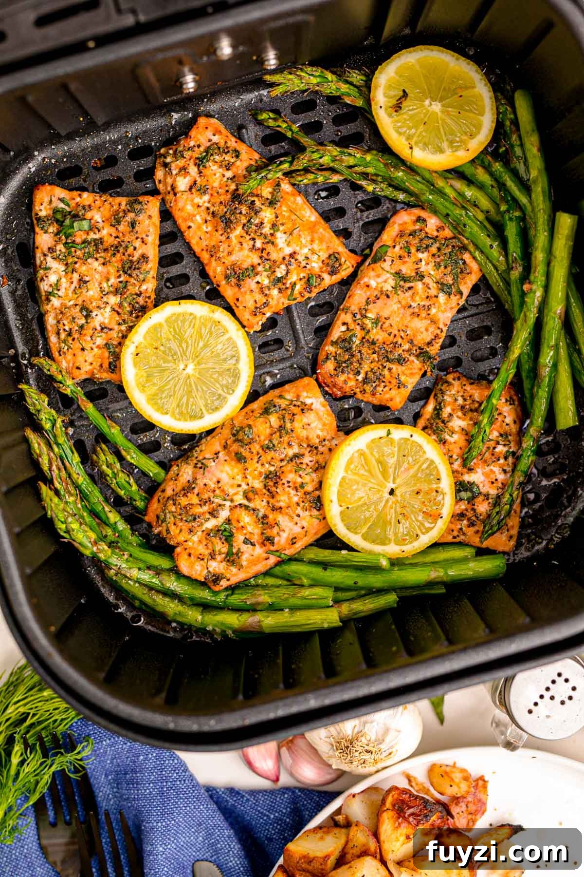Overhead photo of salmon being cooked in an air fryer with asparagus.
