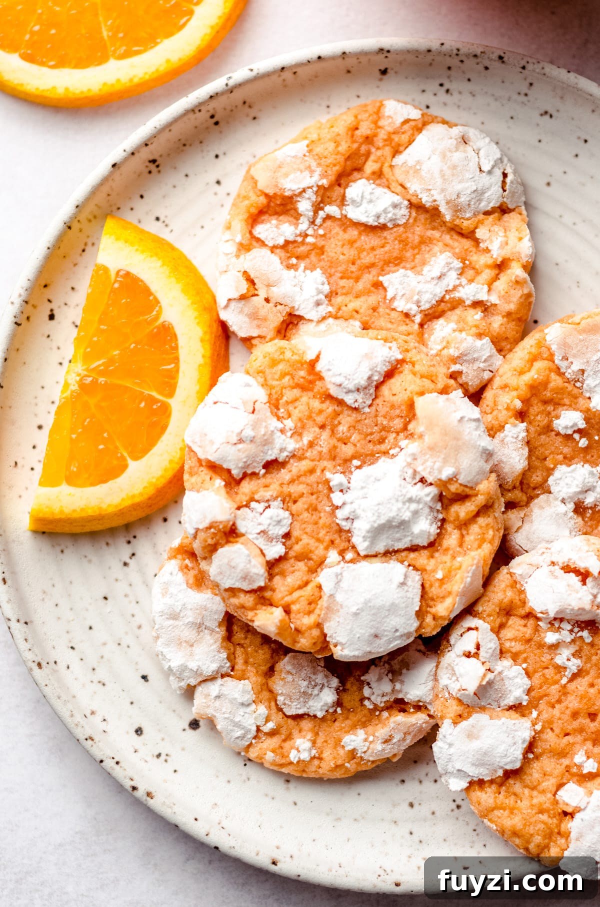 aerial photo of orange creamsicle cookies on a plate with orange slices