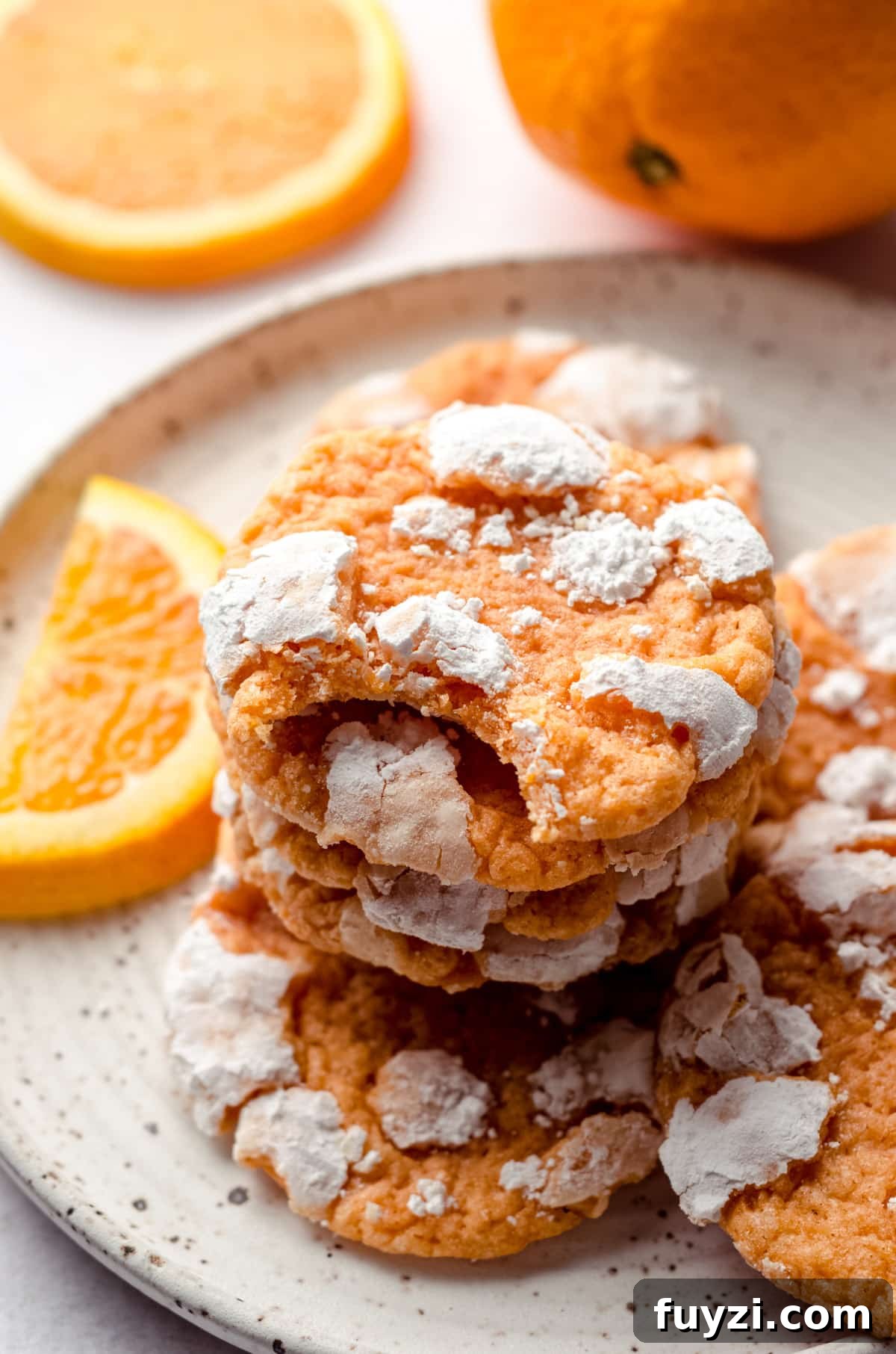 a stack of orange creamsicle cookies with a bite taken out of the one on the top