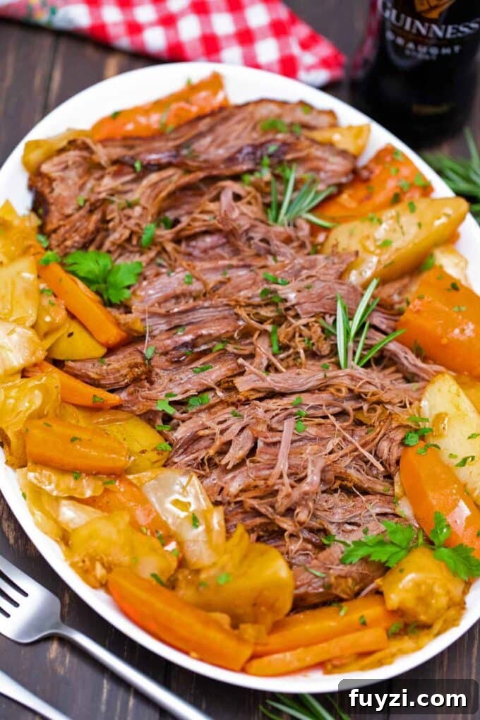 Slow-Cooked Guinness Pot Roast Recipe 11 shredded Guinness pot roast with veggies on a serving plate
