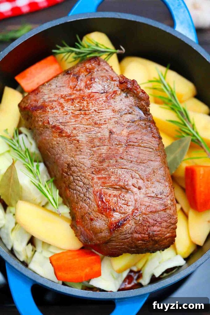 Slow-Cooked Guinness Pot Roast Recipe 8 beef brisket on top of veggies in a Dutch oven