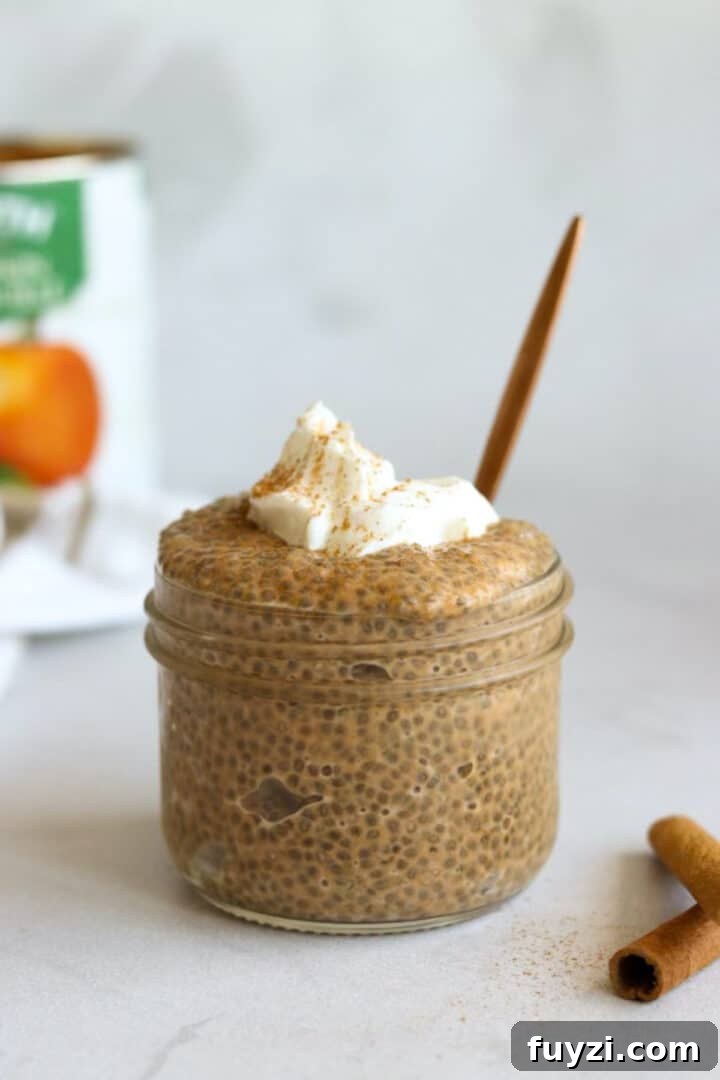 Photo of a jar of pumpkin chia seed pudding with a gold spoon on a white kitchen counter