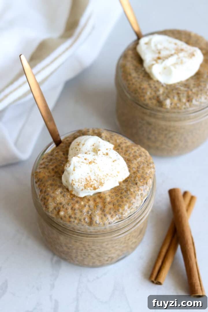 Two jars with pumpkin chia seed pudding topped with greek yogurt and cinnamon