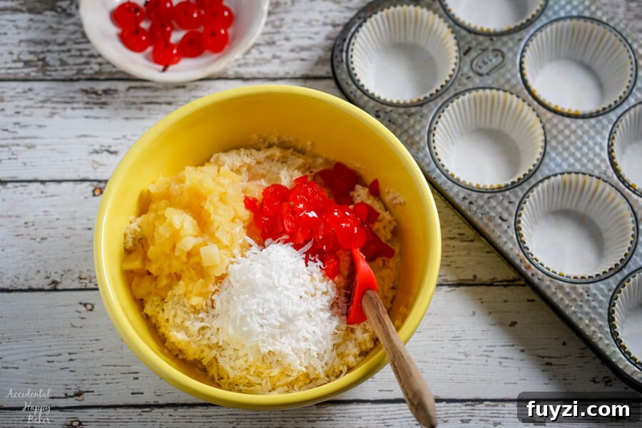 Coconut Rum Malibu Muffins with Pineapple Glaze Recipe 3 A yellow bowl with muffin batter beside a muffin tin.