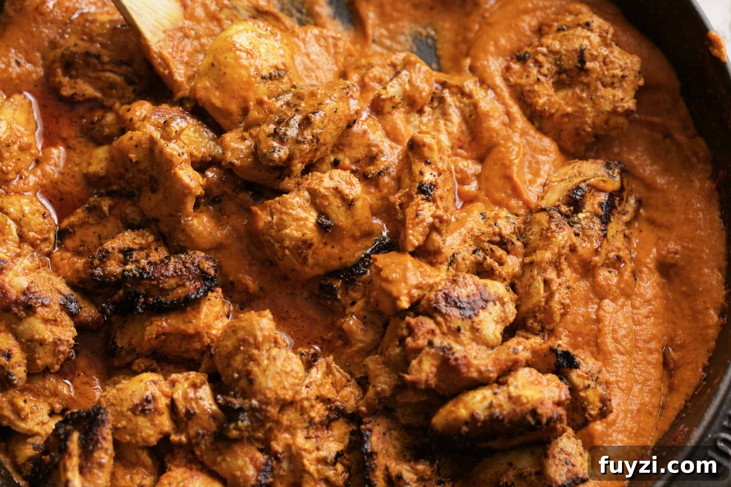 butter chicken covered with mix being cooked