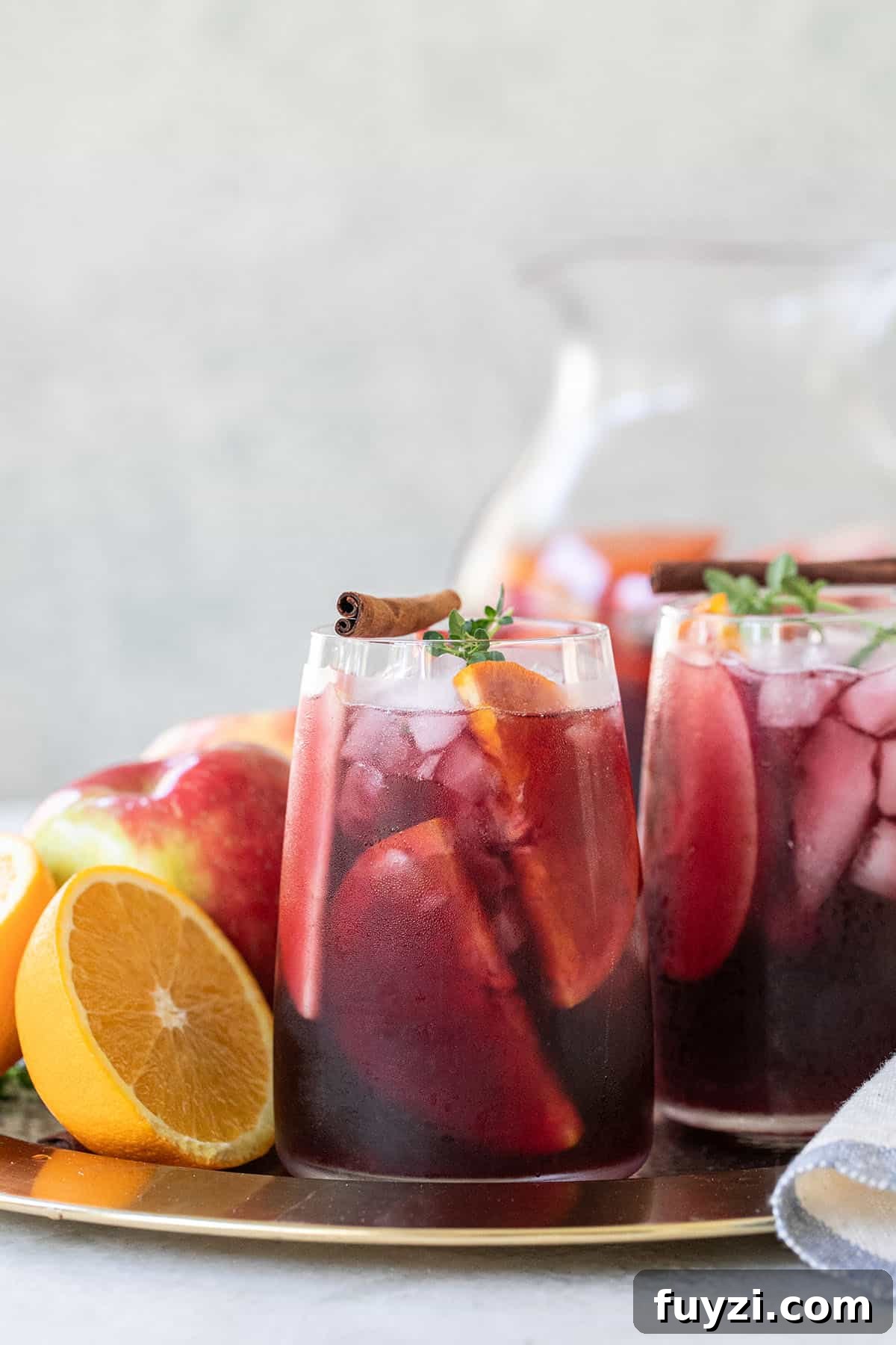 Spiced Autumn Apple and Pear Sangria Recipe 2 Fall sangria in a glass with cinnamon, thyme and an orange slice.
