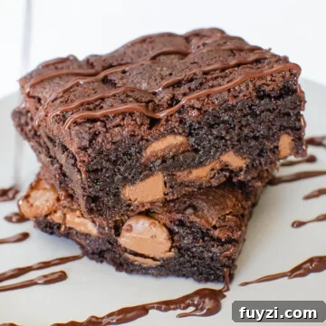 Chunky Chocolate Chip Brownies on a grey plate drizzled with chocolate sauce