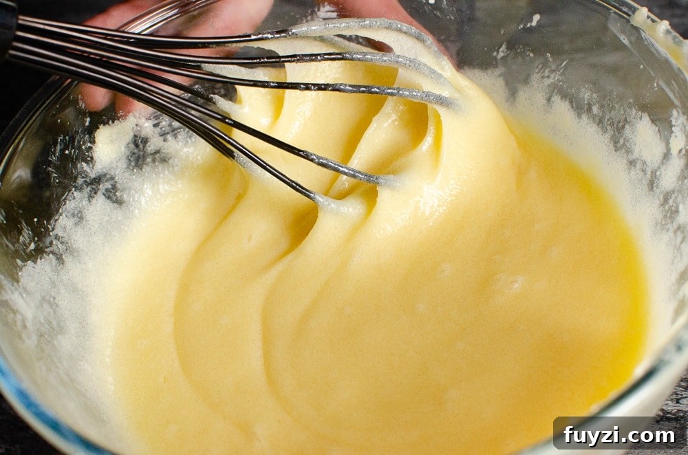 Fudgy Chunky Chocolate Chip Brownies Recipe 16 Whisking the butter mixture in a glass bowl with a black whisk